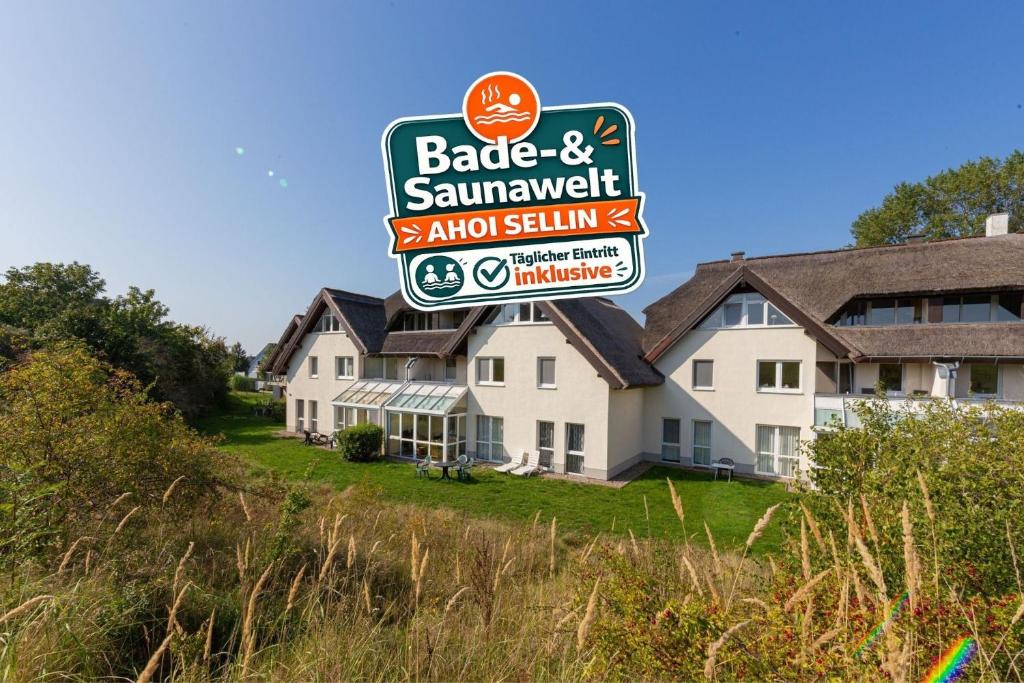a sign in front of a building with a house at Strandhaus Lobbe, Sanddorn Nr 3 - Bade- & Saunawelt täglich inklusive in Lobbe