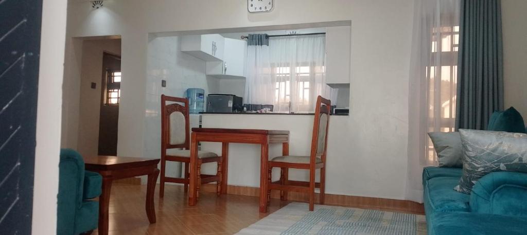 a living room with a table and a kitchen at Lee Njiru Resort in Nakuru