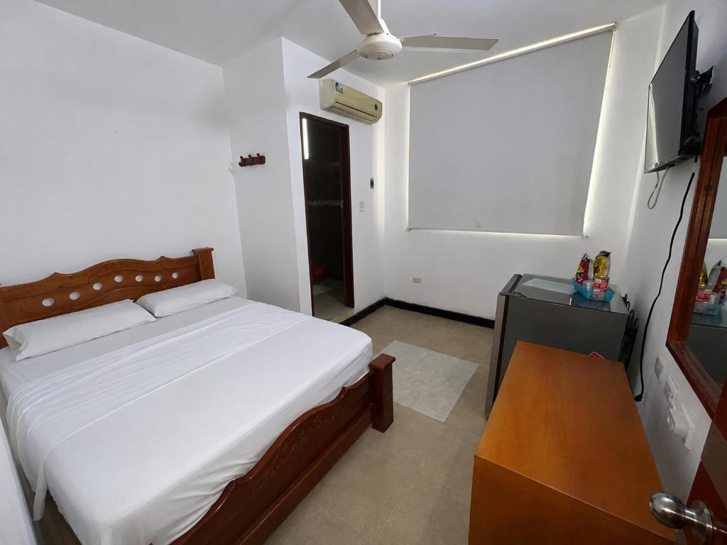 a bedroom with a bed and a flat screen tv at Hotel MAR&ANA in El Banco