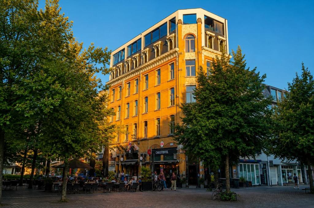 a tall yellow building with a lot of windows at SLEEP INN ANTWERP - Short & Longterm rentals in Antwerp