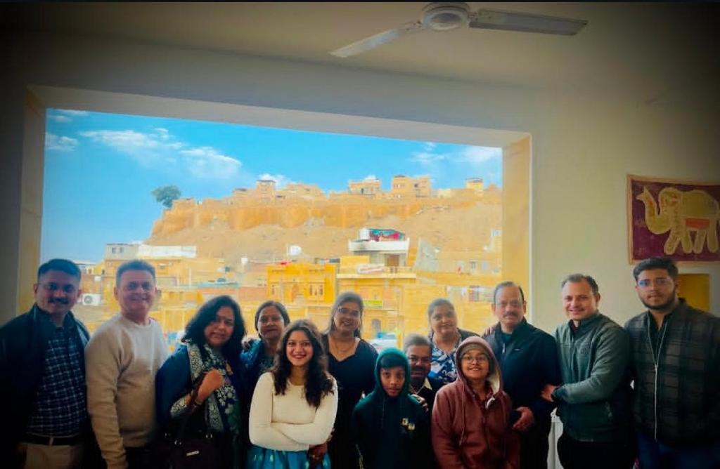 a group of people posing for a picture in front of a painting at Hotel Heaven In Jaisalmer in Jaisalmer