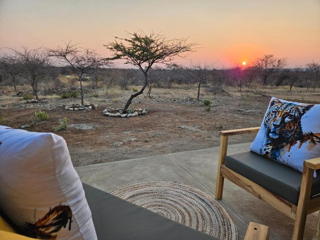 a chair sitting on a porch watching the sunset at Pi-Buddy Lodge and Bushcamp in Outjo