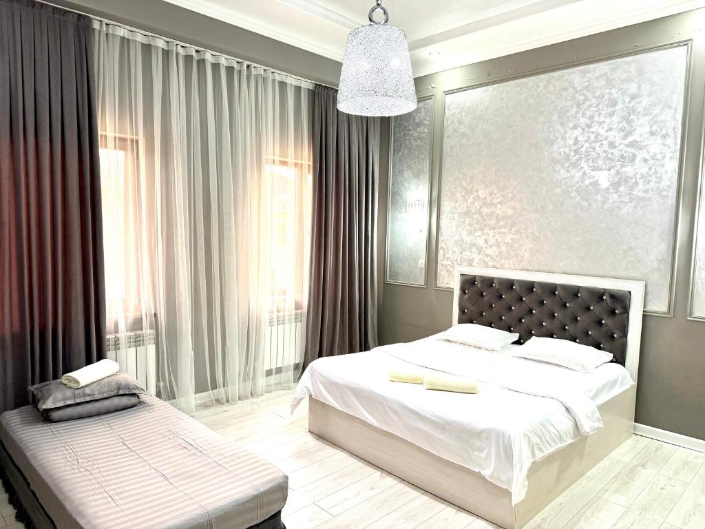 a bedroom with two beds and a large window at Nogai Karavan in Türkistan