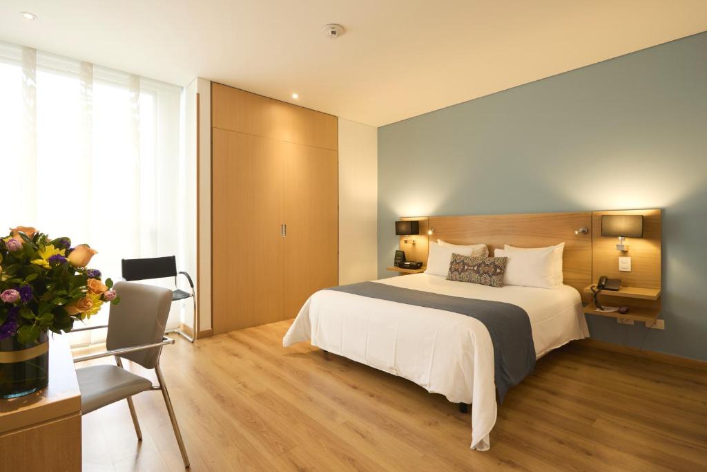 a bedroom with a bed and a desk and a chair at Hotel bh Parque 93 in Bogotá