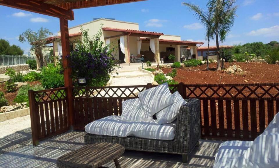 wiklinowy fotel i stół na patio w obiekcie Le Fanciulle w mieście Marina di Pescoluse