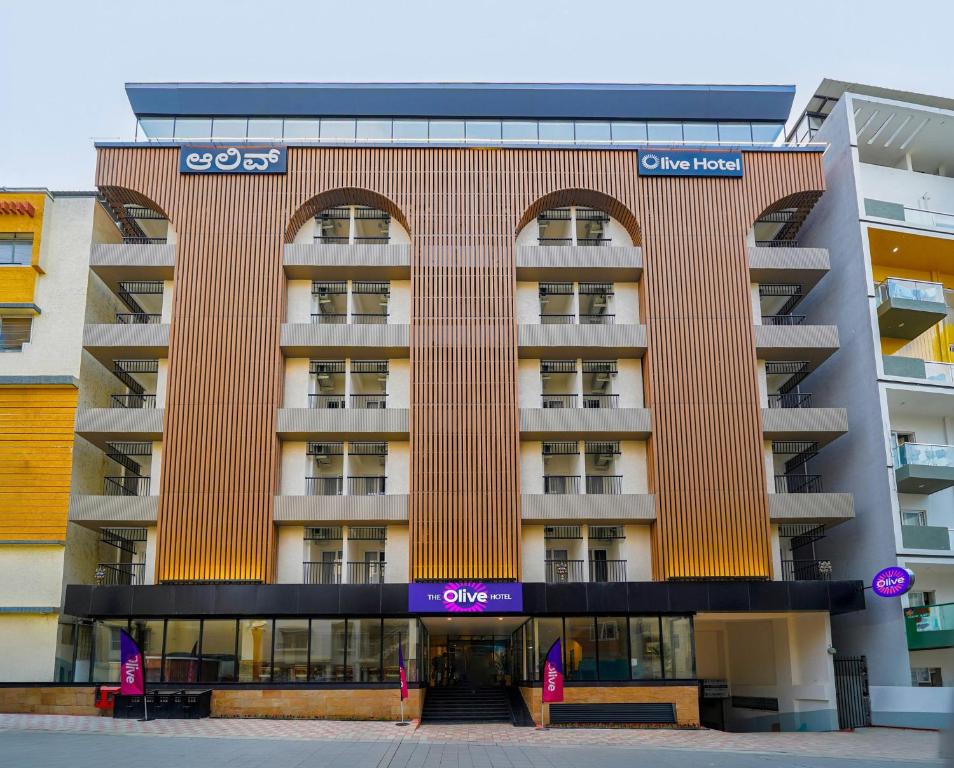 a building with a sign on the front of it at Olive Hotel Nagawara by Embassy Group in Bangalore