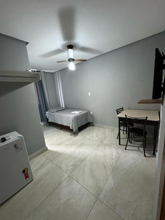 a room with a bed and a table and chairs at Neves Hotel II in Ipatinga