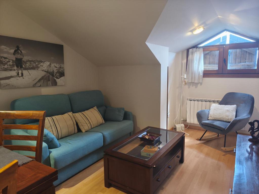 a living room with a blue couch and a table at El nido de Villanua in Villanúa