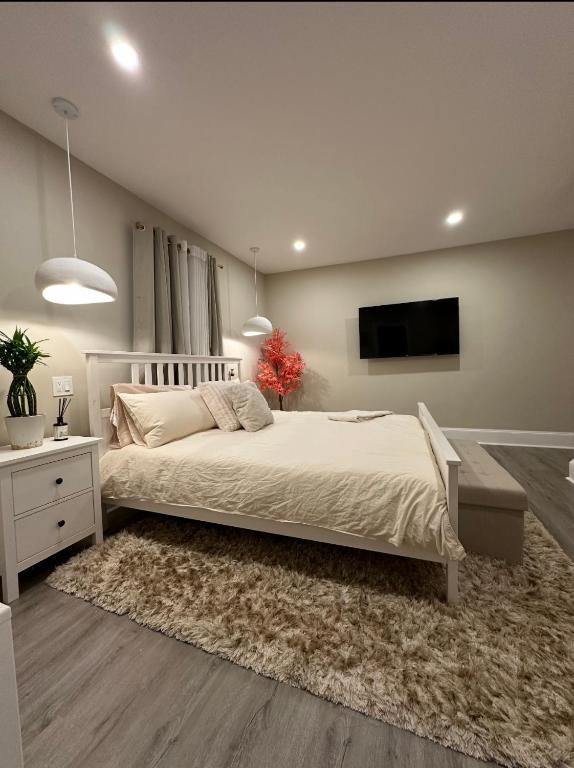 a bedroom with a bed and a tv on a wall at Clinton Rooms - By Outlets and Beach in Clinton