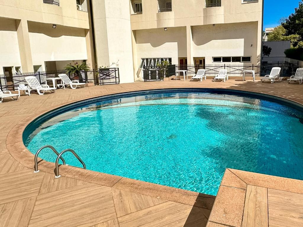 a large swimming pool in front of a hotel at Travel Inn Flats Santo André in Santo André