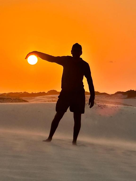 a man running on the beach at sunset at Passeio de buggy leste Jericoacoara in Jericoacoara