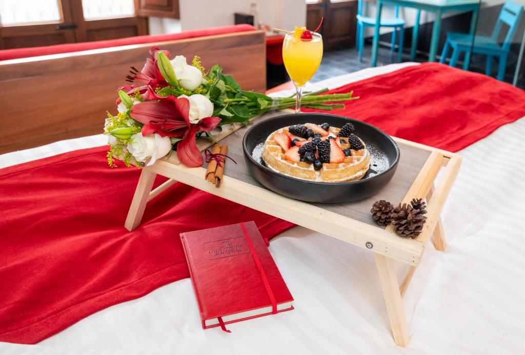ein Teller mit Essen auf einem Tisch auf einem Bett in der Unterkunft Del Carmen Concept Hotel Boutique by Chai in Guadalajara