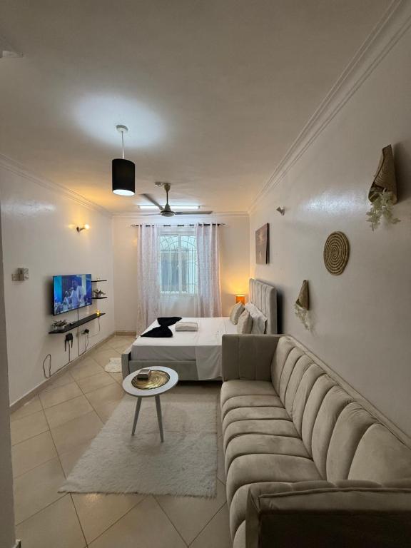a living room with a couch and a bed at Harmony serenity studio apartment in Mombasa