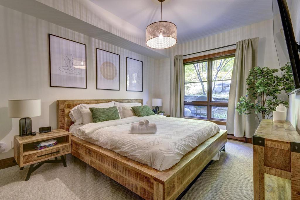 a bedroom with a large bed and a window at Tremblant Prestige - Étoile 1520-2 in Mont-Tremblant