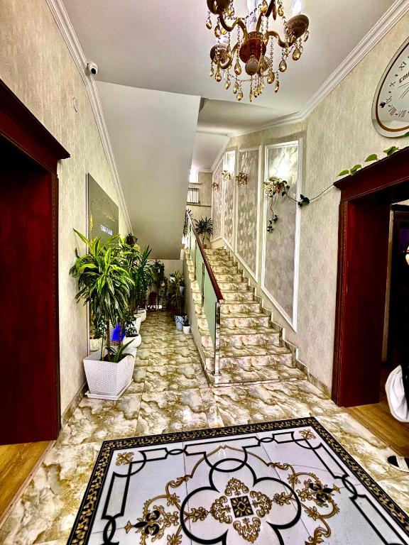 a hallway with a stone floor and stairs with a chandelier at MIR Hotel in Türkistan