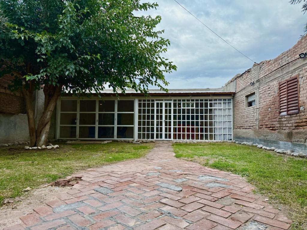 a brick driveway in front of a building with a tree at Los Horneros in Santa María