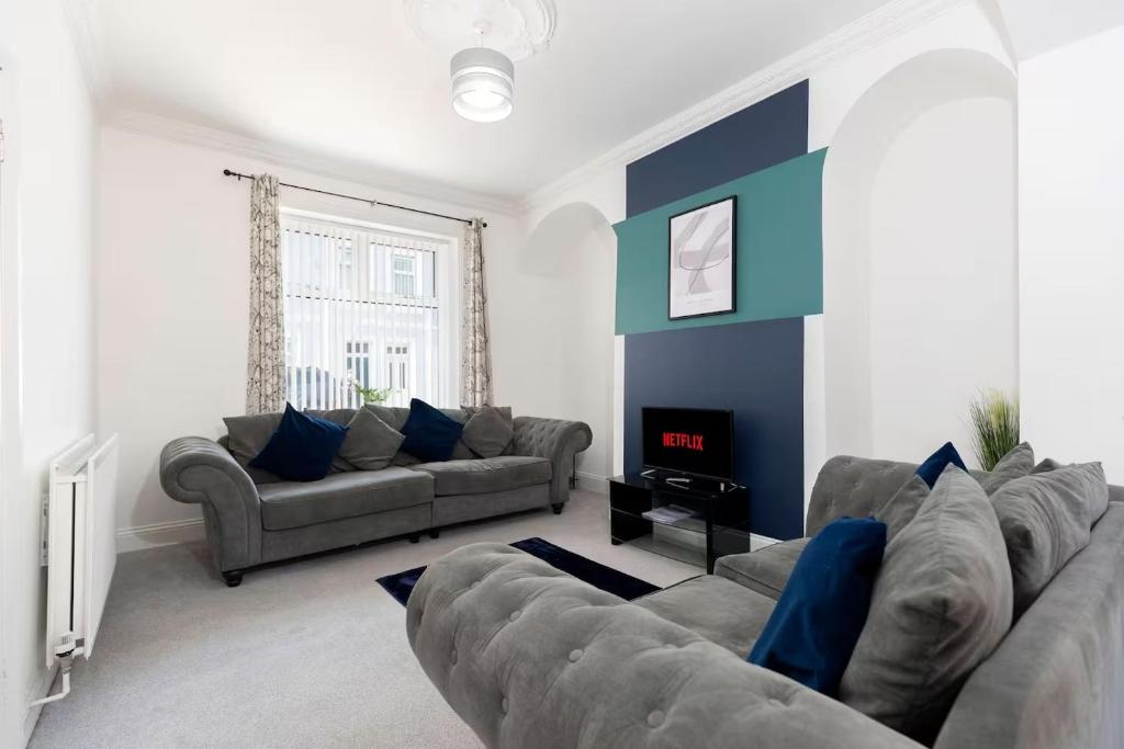 a living room with two couches and a fireplace at 3 Bedroom House In Jarrow, Sleeps 6, Near Port of Tyne & Free Parking in Jarrow
