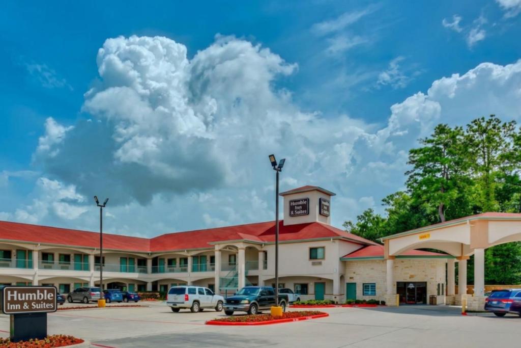 a large building with cars parked in a parking lot at Humble Inn & Suites in Humble