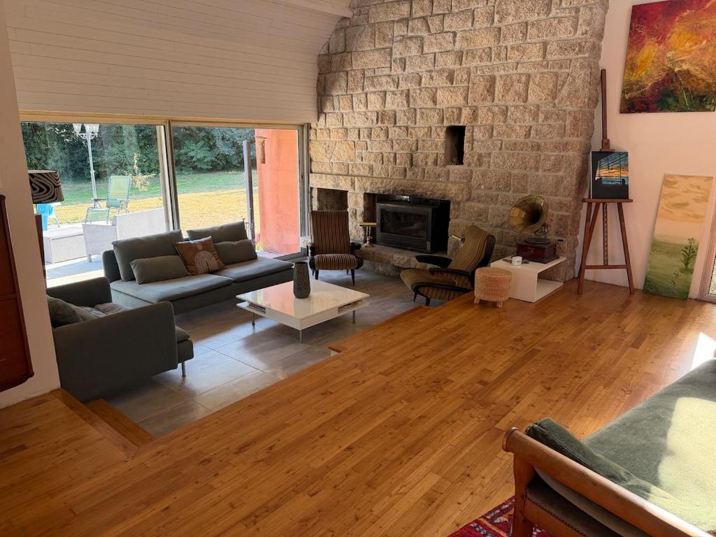a living room with a couch and a fireplace at Maison de charme 209m2 in Coray