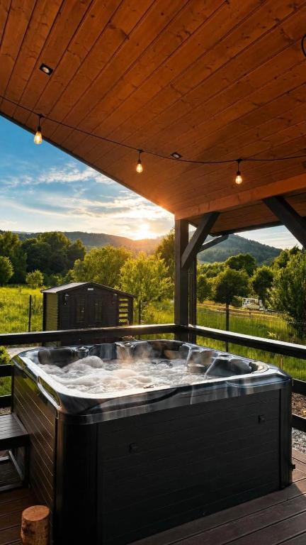 a hot tub on a deck with a wooden roof at Karkonosze pod gwiazdami in Jarkowice