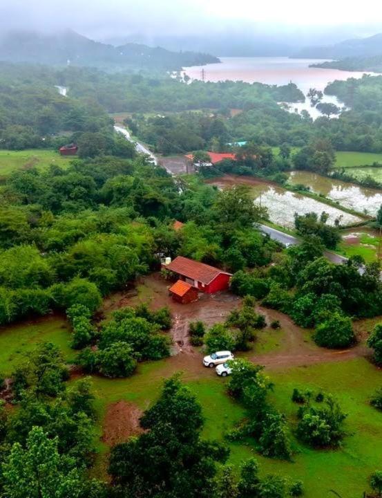 an aerial view of a house with cars parked in a field at K Bhoomi Joy by Earth in Bhīra Camp