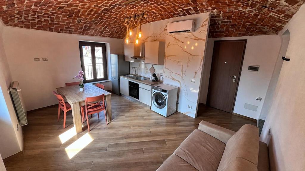 a living room with a table and a kitchen with a microwave at Il Grappolo in Gattinara