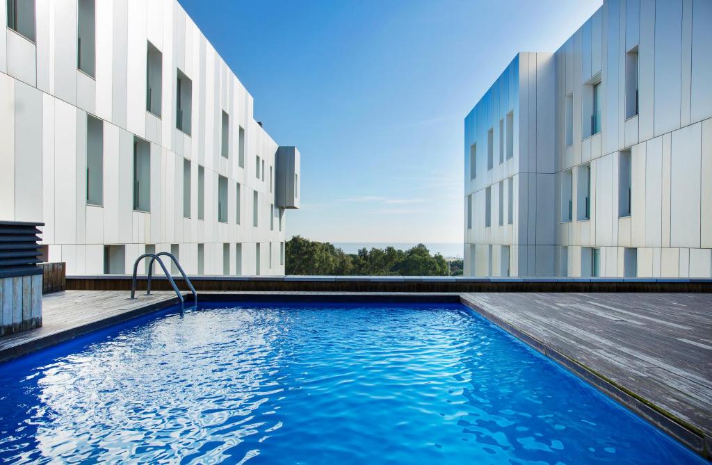 a swimming pool in front of a building at Durlet Beach Apartments in Barcelona