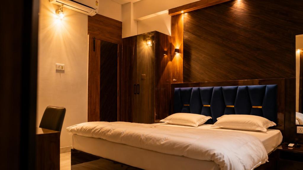a bedroom with a large bed with a blue headboard at Hotel Prince Paradise in Patna
