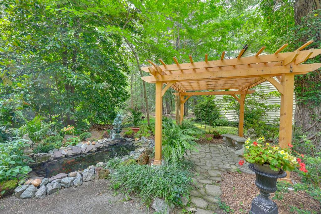 a wooden pergola in a garden with a pond at Pool Access! Cozy Couple's Getaway in Kilmarnock in Kilmarnock