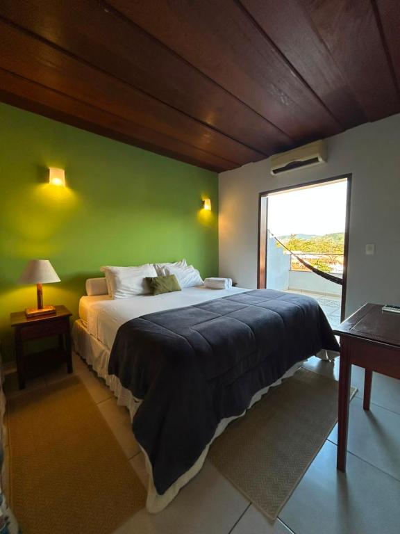 a bedroom with a large bed with a green wall at Pousada Solar D Alcina in Paraty