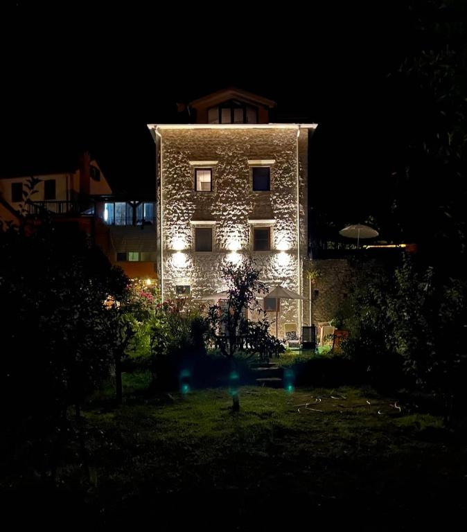 a large stone building with lights on it at night at Apartment Marci in Donji Morinj