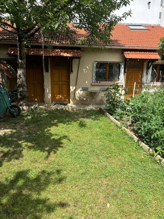 a house with yellow doors and a grass yard at Studio climatisé in Paray-Vieille-Poste