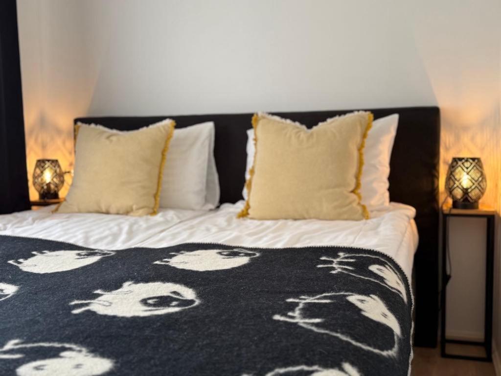 a bed with a black and white blanket and pillows at Žalčio guolis in Lekėčiai