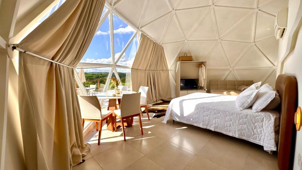 a bedroom with a tent with a bed and a table at Natureza e luxo in Alagoa Nova