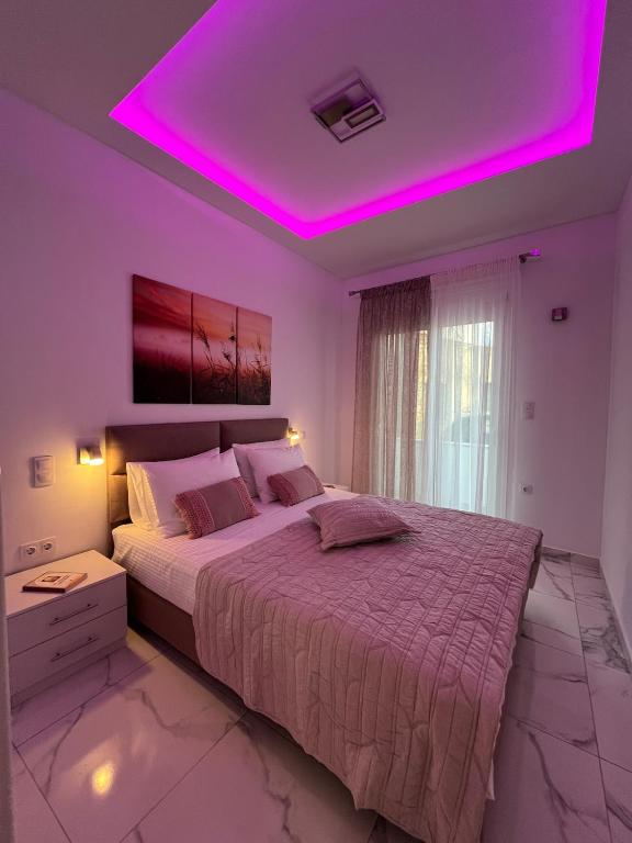 a bedroom with a large bed with a purple lighting at Salamina Downtown Apartment East in Salamina