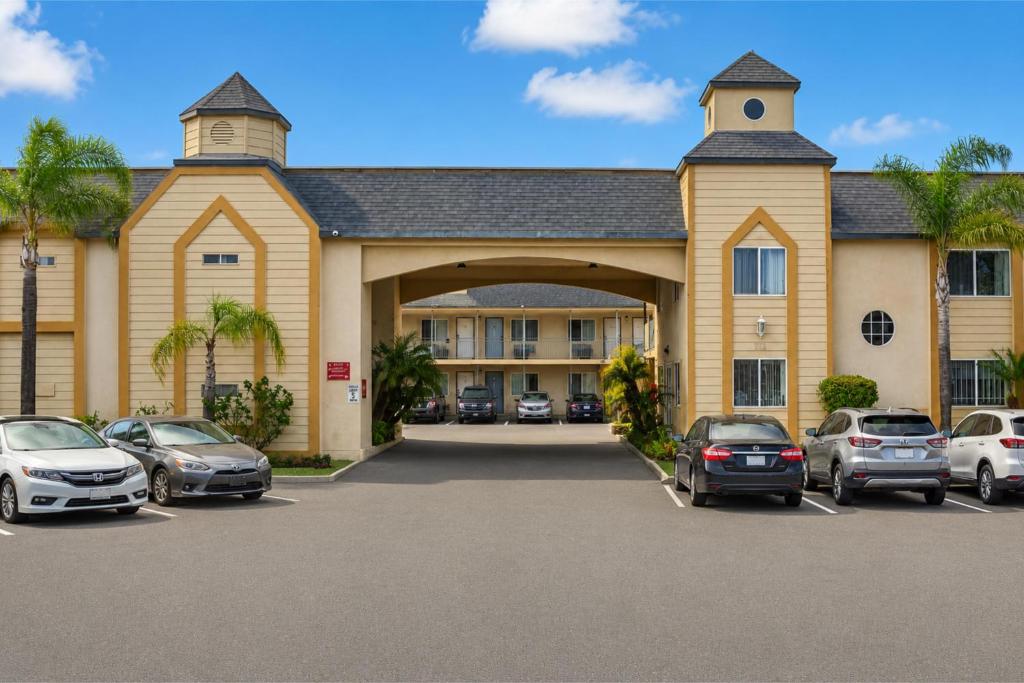 a large building with cars parked in a parking lot at Del Playa Inn Oxnard Near Camarillo in Oxnard