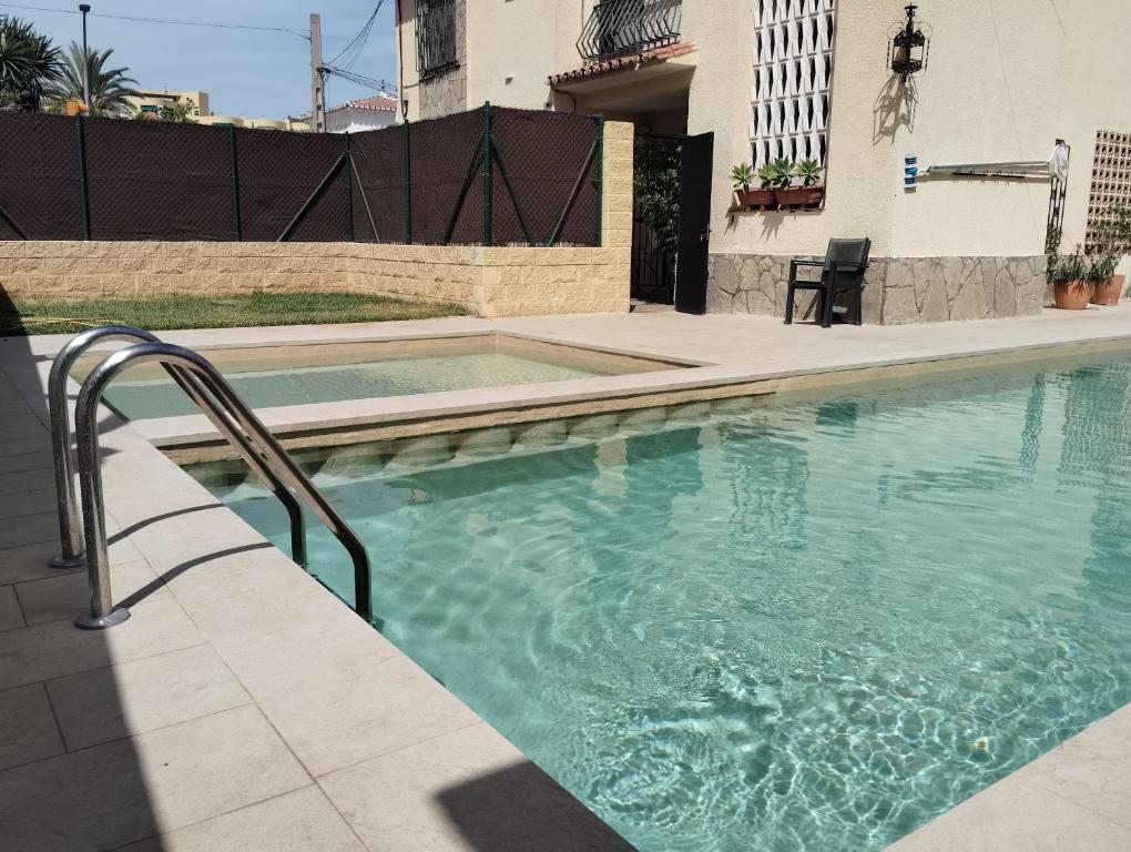 a swimming pool in a yard with a building at Chalet Puerto Marina Goya in Benalmádena