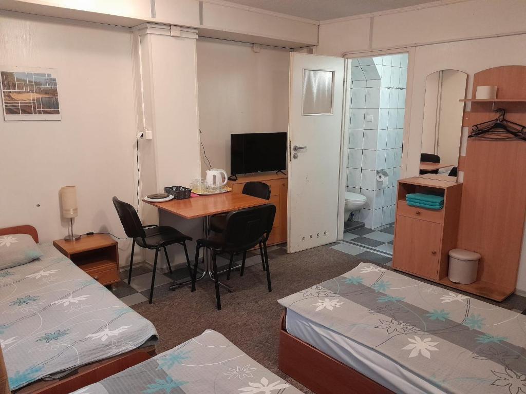 a room with a room with two beds and a desk at Pokoje Slomkowscy in Łódź