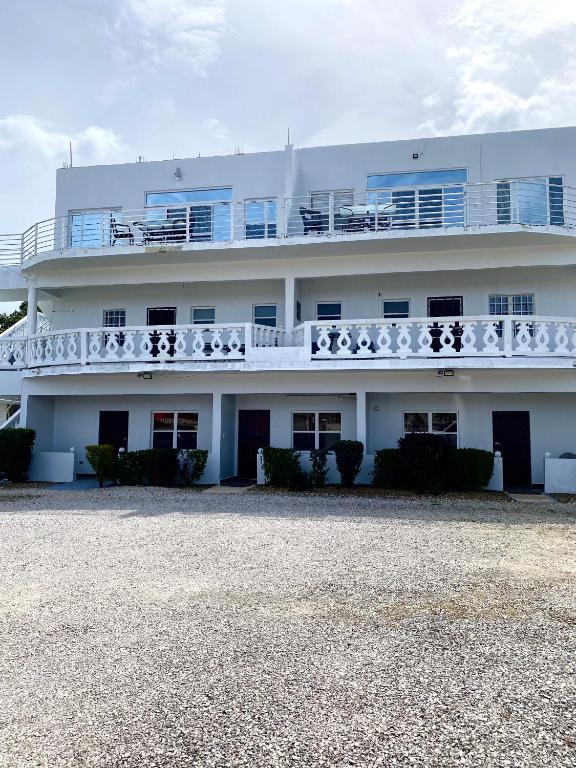 a white building with a balcony on top of it at The Ansen Place in Belmopan