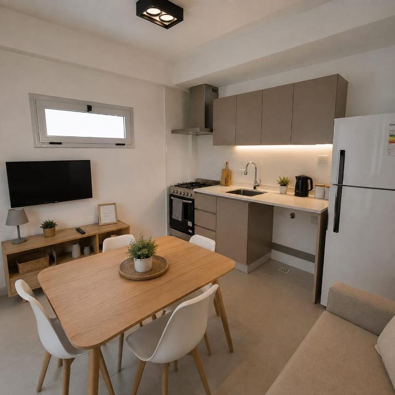 a kitchen and dining room with a table and a refrigerator at Hotel Castelar suit in Castelar