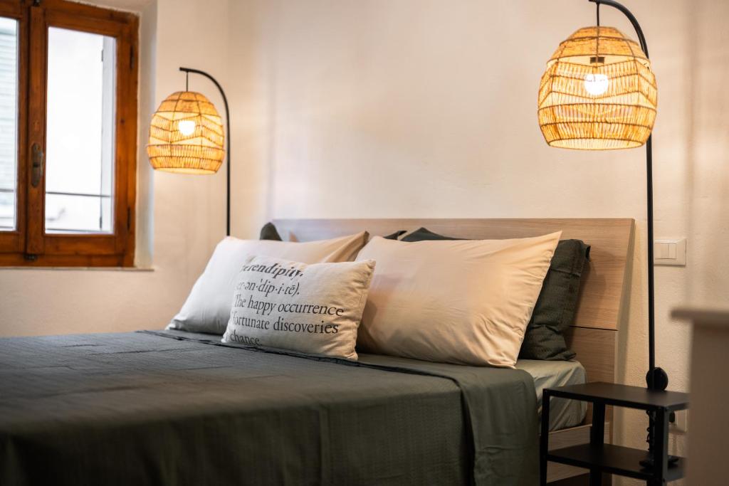 a bedroom with two lamps and a bed with two pillows at Porta Toscana in Poggibonsi