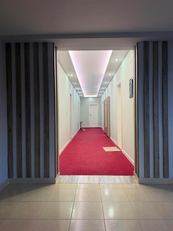 an empty hallway with a red carpet and a ceiling at Hotel, Bar, Restaurant Beni in Vlorë