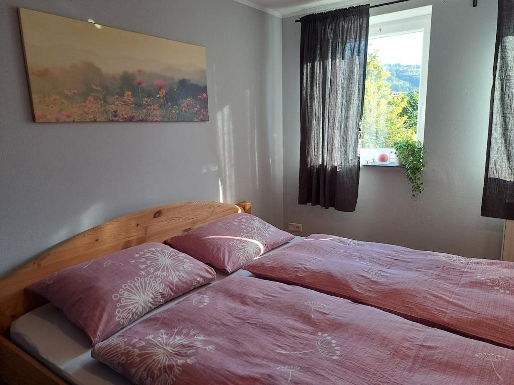 a bedroom with a bed with pink sheets and a window at NaturGenuss Wittgenstein in Bad Laasphe