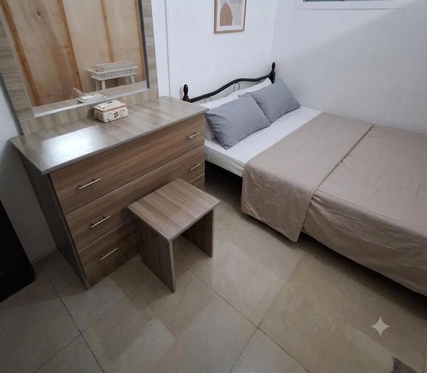 a bedroom with a bed and a dresser with a sink at Hidden Villa in Al Ain