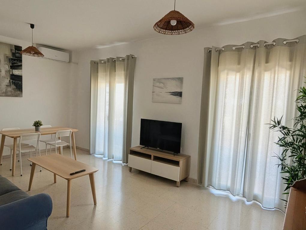 a living room with a television and a table at Apartamento Casa Balina II in Dúrcal