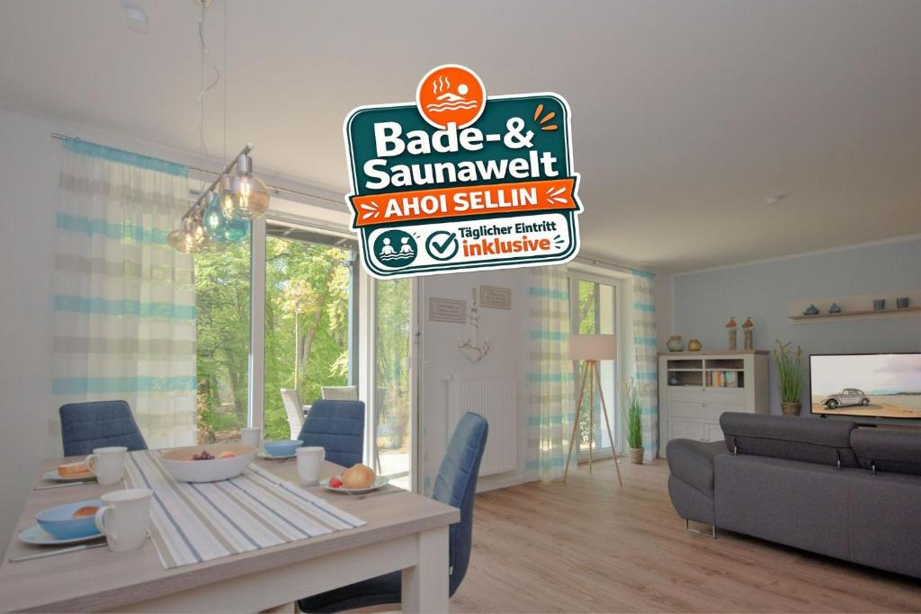 a living room with a table and a sign on the wall at Haus Waldidyll, Küstenflair - Bade- & Saunawelt täglich inklusive in Ostseebad Sellin