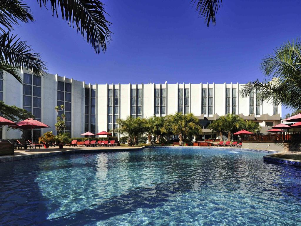 a large swimming pool in front of a hotel at Pullman Lubumbashi Grand Karavia. in Lubumbashi