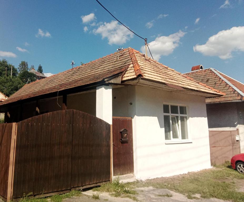 a small white house with a wooden fence at Pod kláštorom in Svätý Beňadik