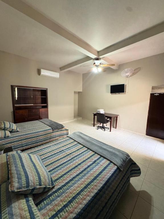 a hotel room with two beds and a desk at Dormitorio in Juticalpa