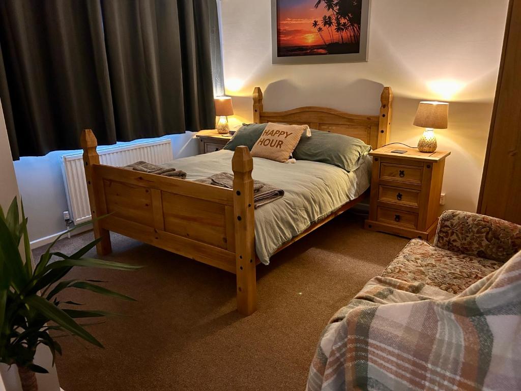 a bedroom with a wooden bed and a chair at Peaceful Coastal Escape in Old Colwyn